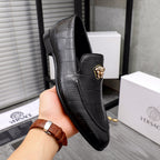 Black leather loafer with front gold emblem and textured panel stitching