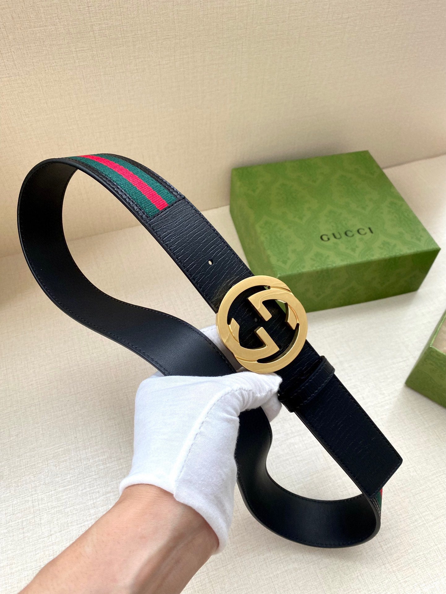 Gucci belt, dark navy strap with multicolor web stripe, gold double-G buckle
