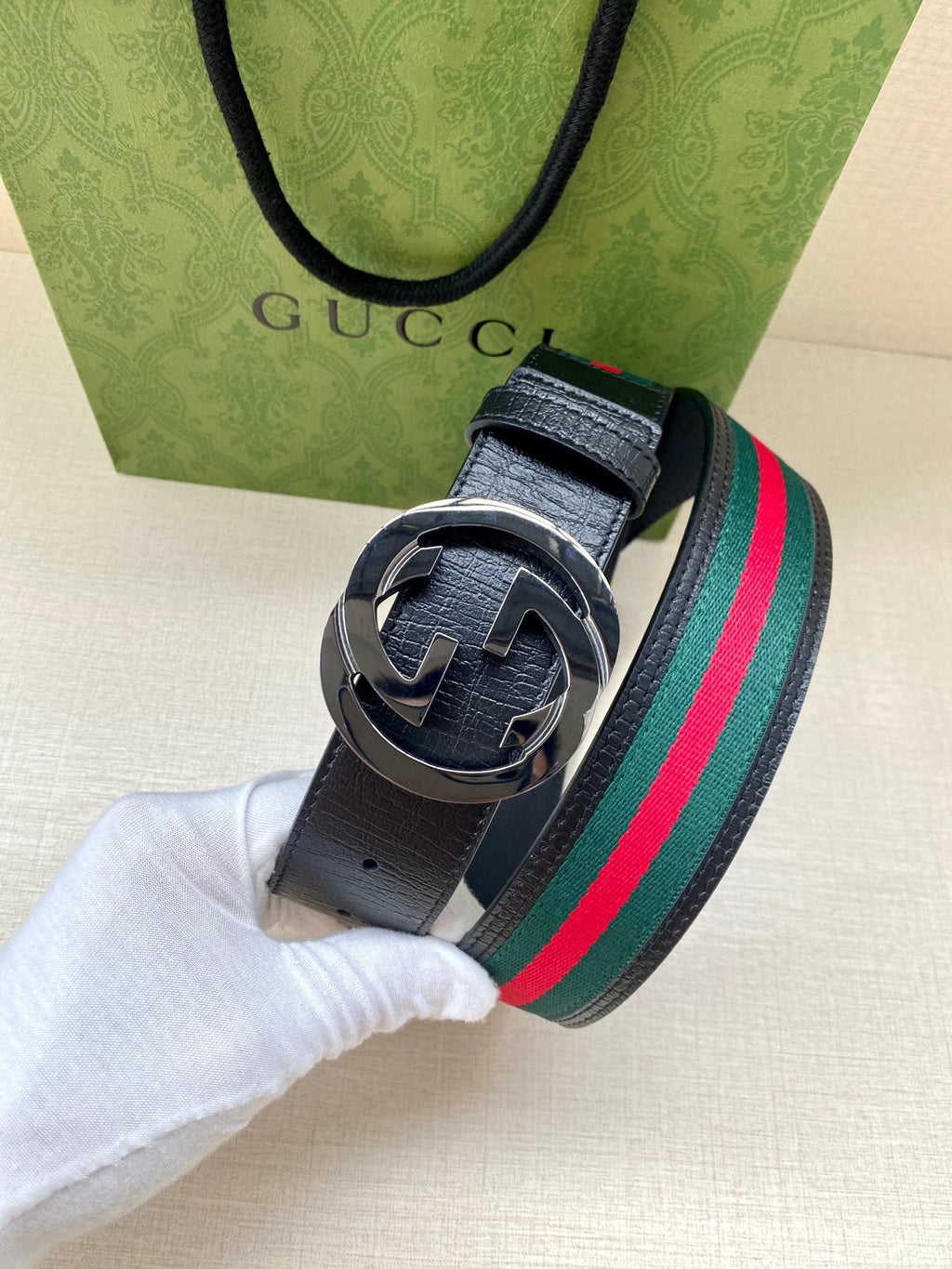 Gucci belt with navy strap, multicolor stripe, dark-toned double-G buckle closeup