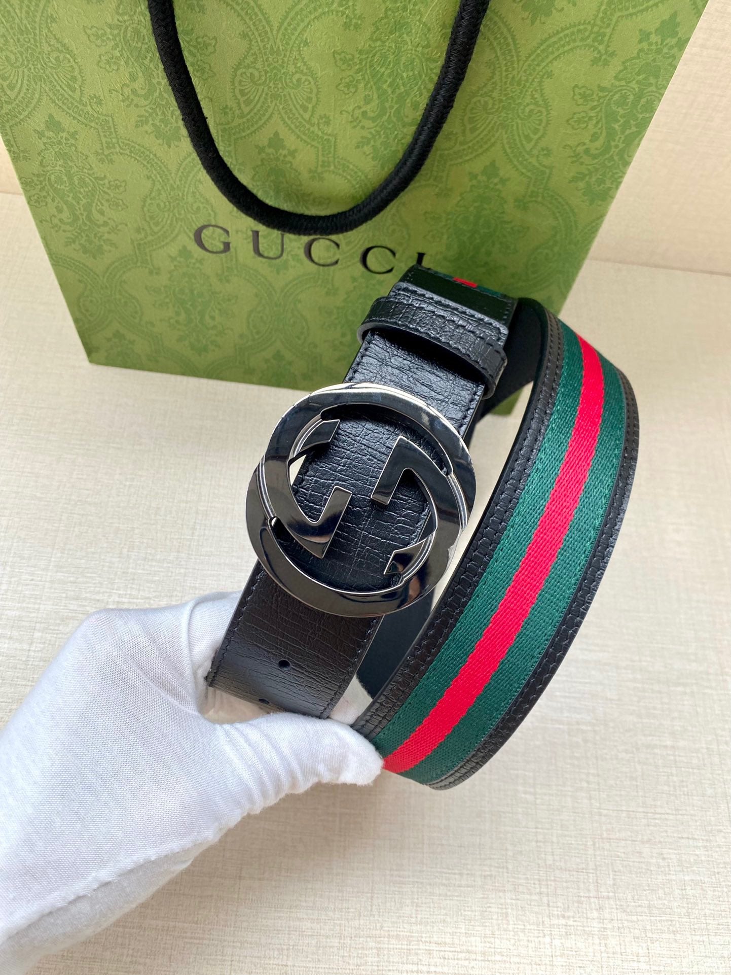 Gucci belt with navy strap, multicolor stripe, dark-toned double-G buckle closeup
