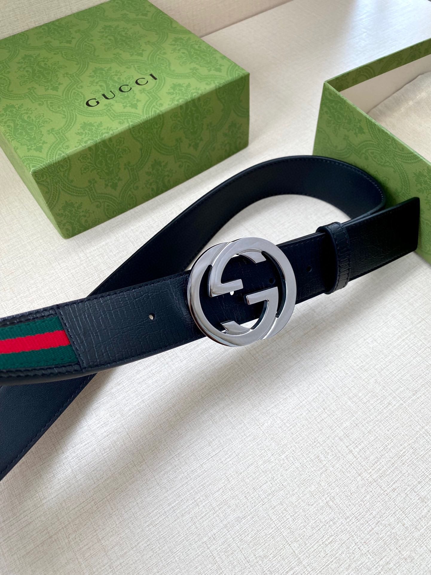 Gucci belt, dark navy leather and multicolor stripe, silver double-G buckle closeup