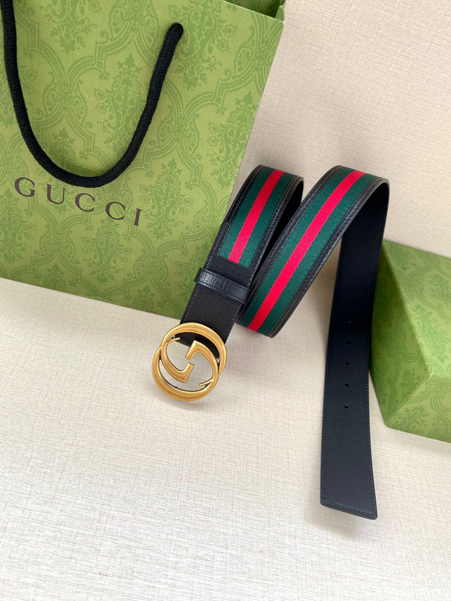 Navy leather belt with gold double-G buckle and multicolor striped webbing
