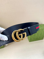 Gucci belt, side view: dark navy strap with gold double-G buckle and green/red web stripe.