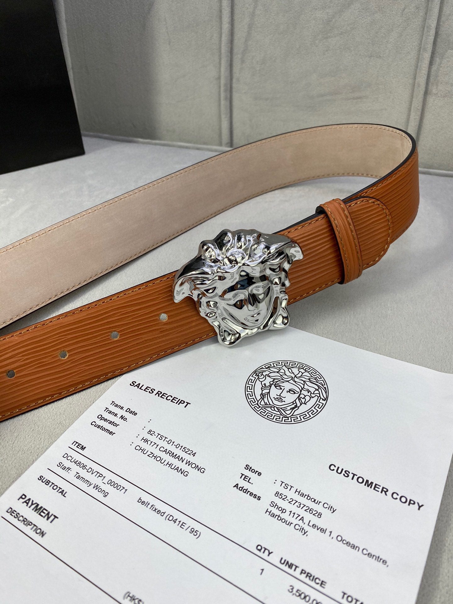 Orange leather belt with silver-toned Medusa buckle and beige underside