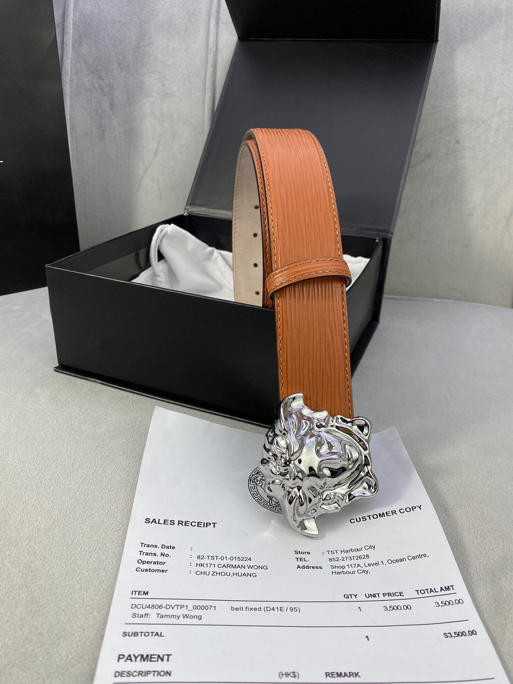 Orange leather belt with silver-toned Medusa buckle, upright strap with stitched edge