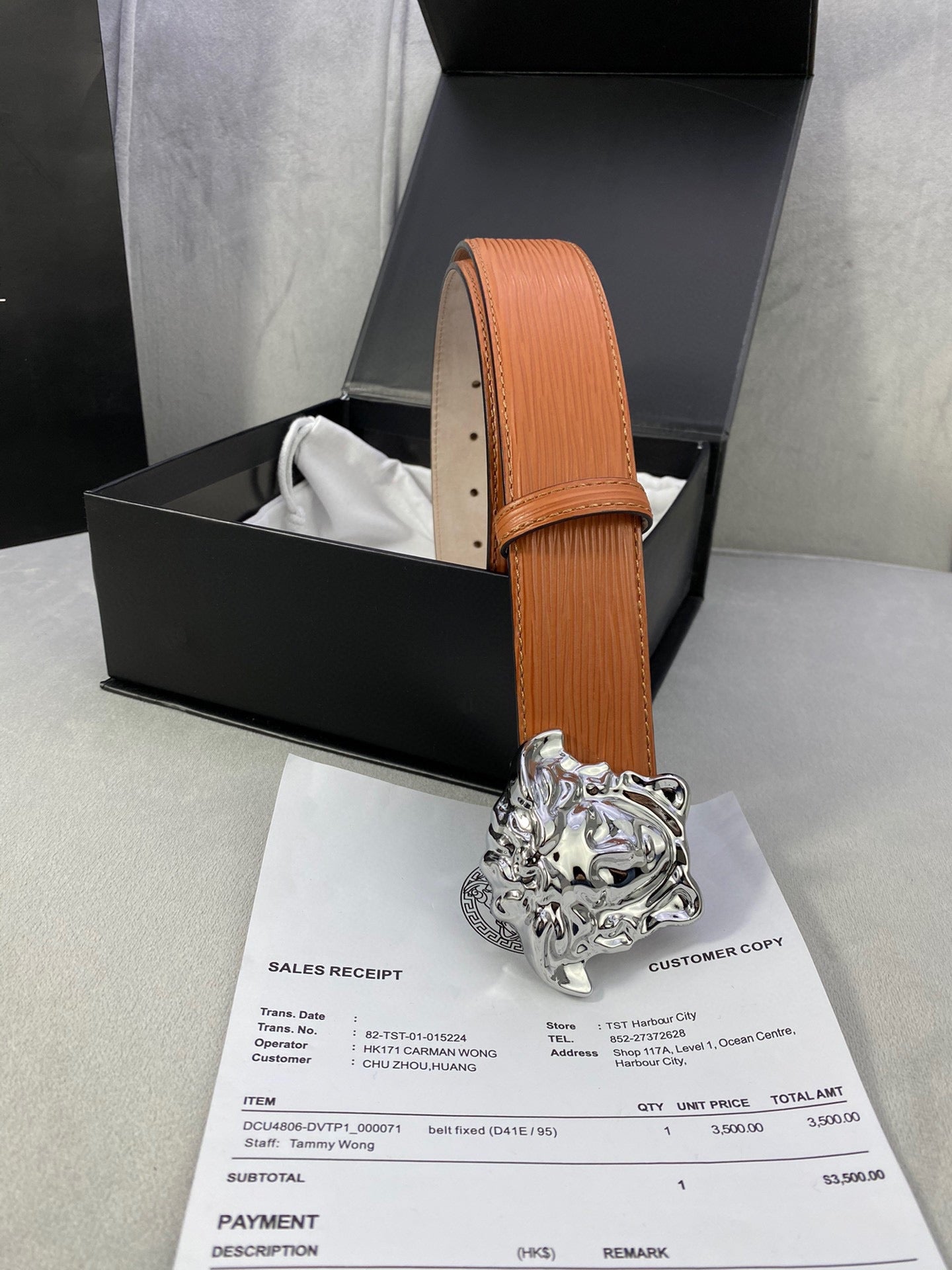 Orange leather belt with silver-toned Medusa buckle, upright strap with stitched edge