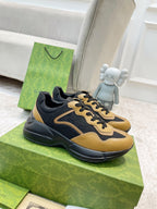 Gucci unisex low-top sneaker, black and tan with gold trim and lace-up design