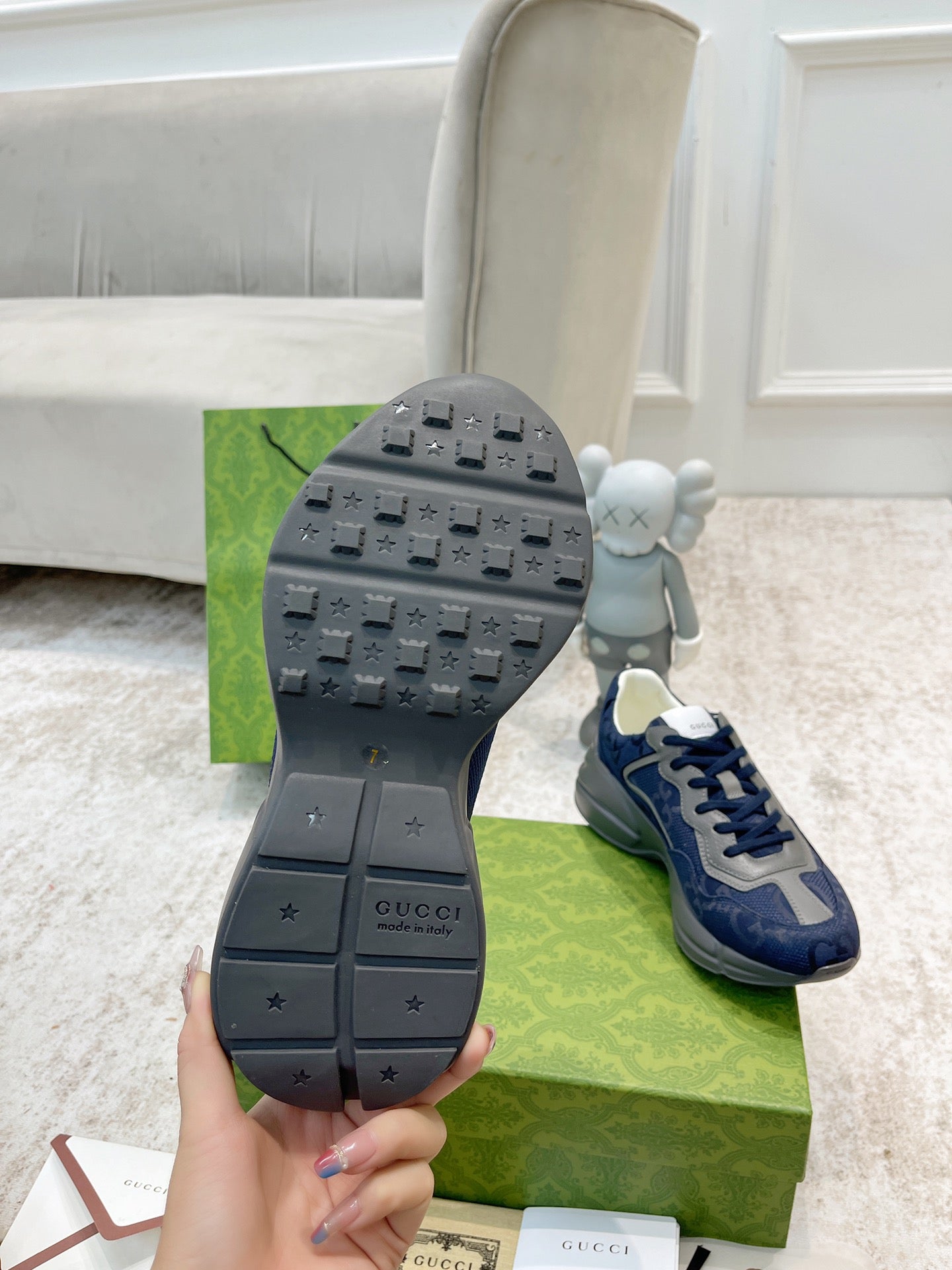Gucci unisex sneaker outsole with dark gray tread and navy shoe upper.