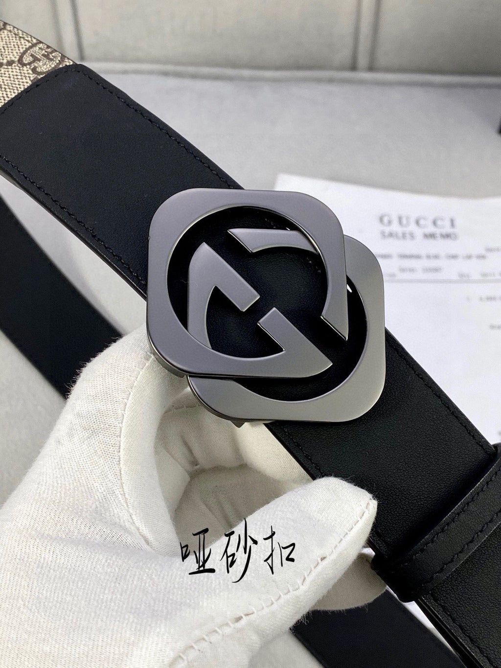 Close-up Gucci belt: black leather strap with silver-toned GG logo buckle