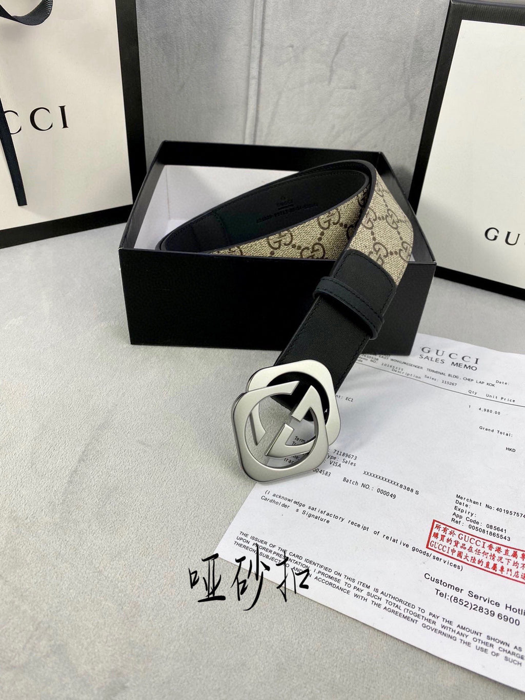 Gucci belt with black leather strap and silver-toned GG buckle, shown with box accessories