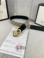 Gucci belt with tan GG canvas panel, black leather strap, and gold-toned GG buckle