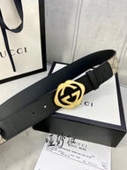 Gucci belt with black leather strap and large gold-toned GG logo buckle