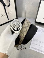 Gucci belt with black leather strap and tan GG canvas backing, silver-toned GG buckle