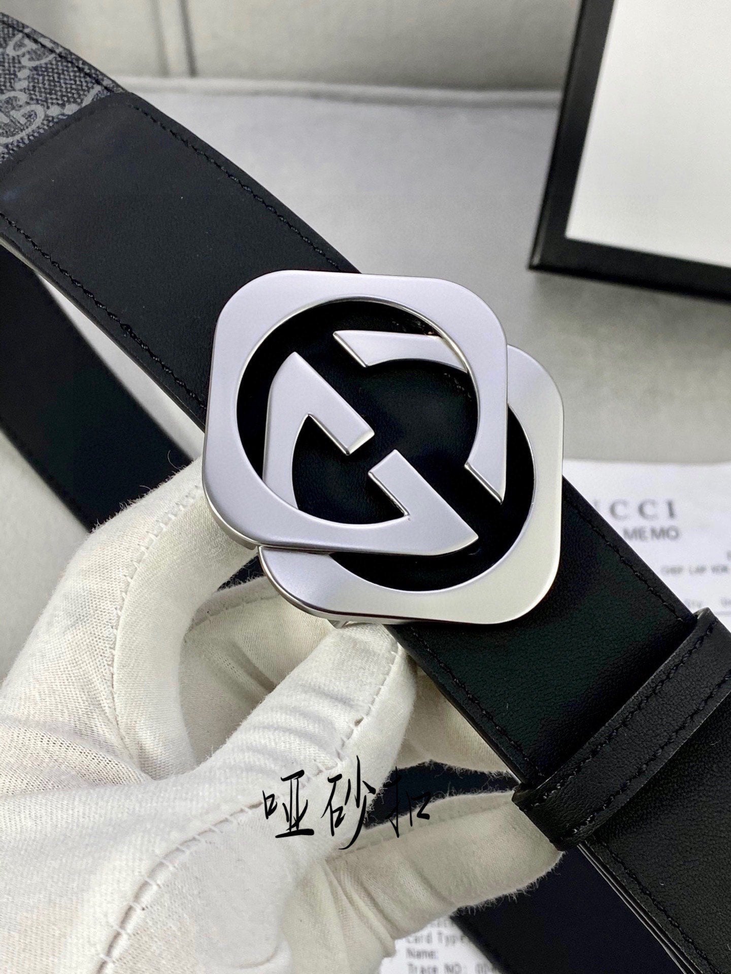 Black Gucci belt with GG monogram strap and silver-tone interlocking buckle detail.