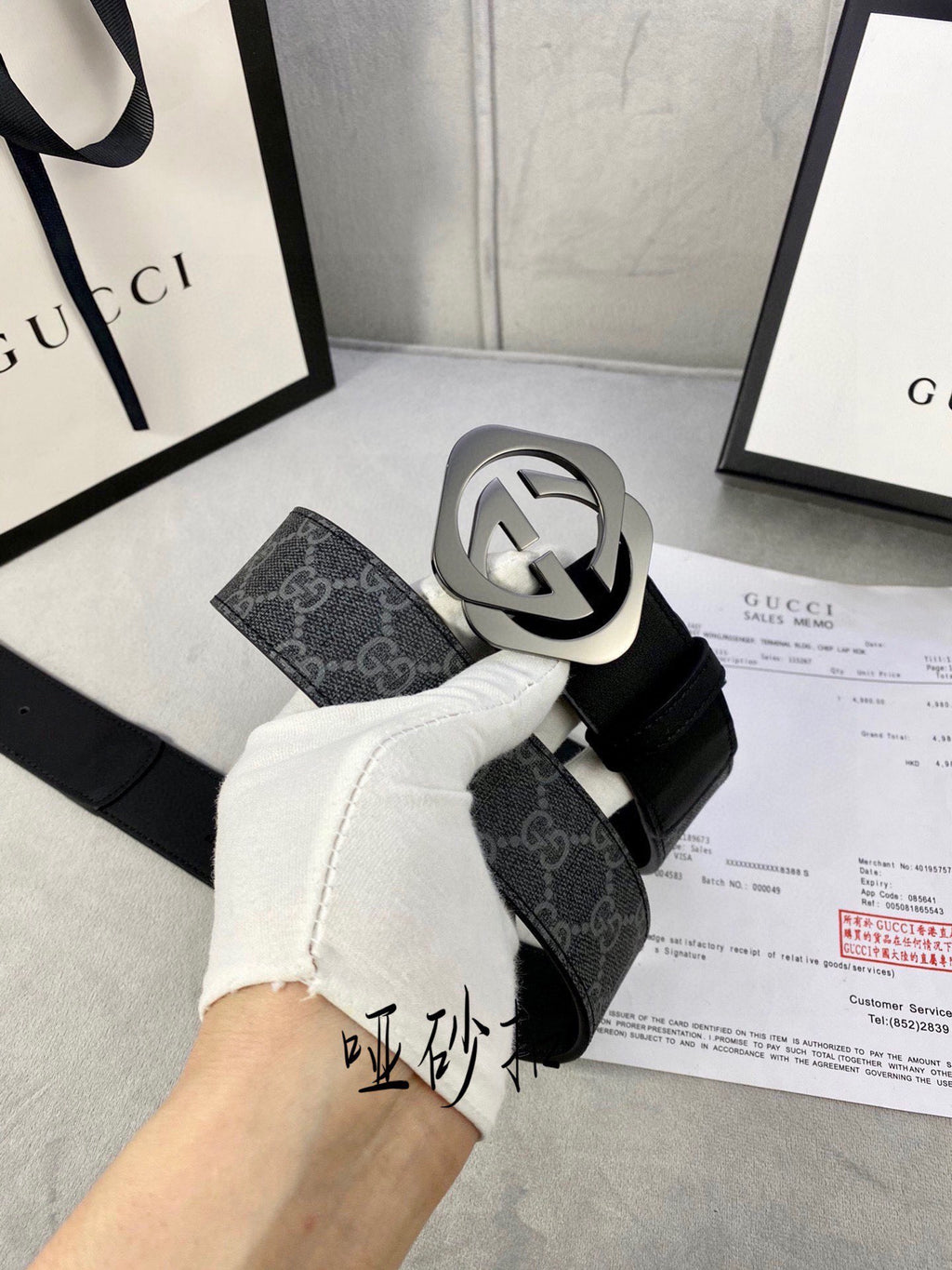 Black Gucci belt with GG monogram strap and large silver-tone interlocking buckle.