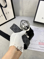 Black Gucci belt with GG monogram strap and large silver-tone interlocking buckle.