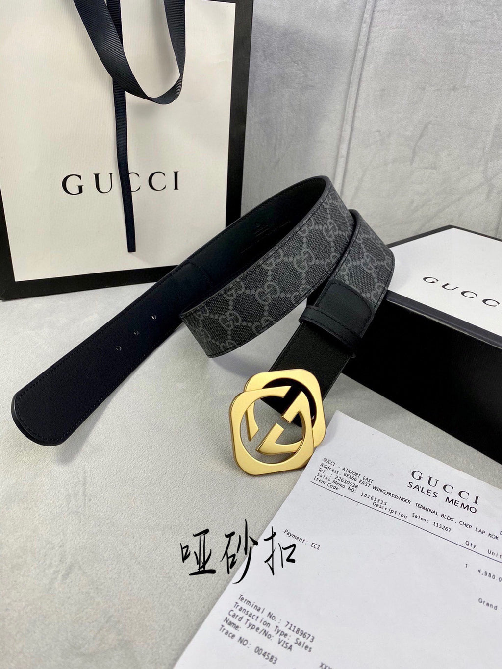 Black Gucci belt with GG monogram strap and gold-tone interlocking buckle.