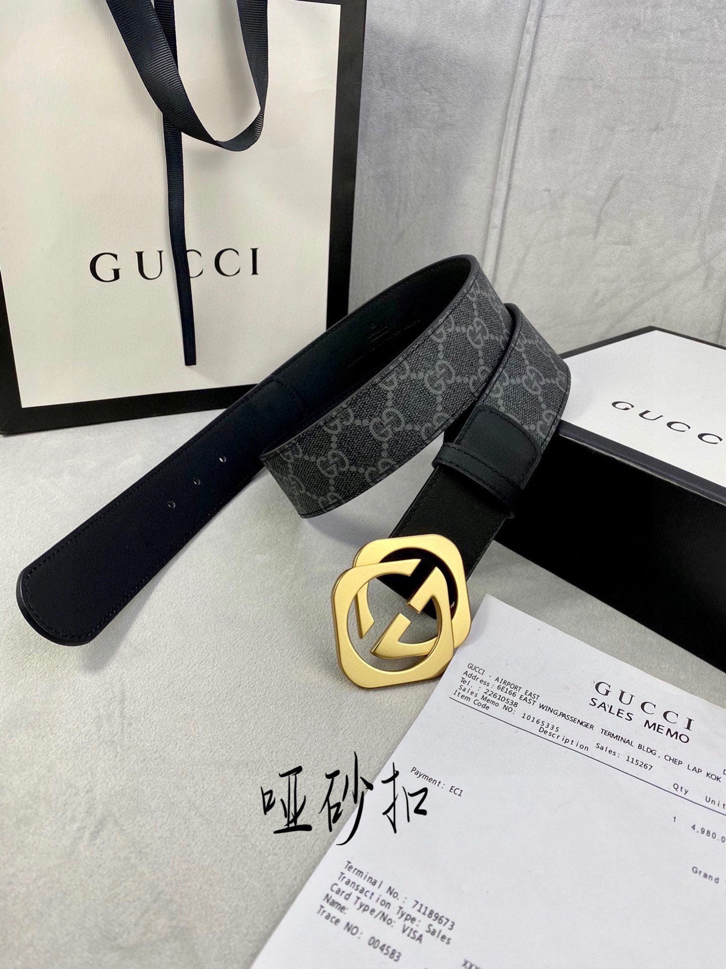 Black Gucci belt with GG monogram strap and gold-tone interlocking buckle.