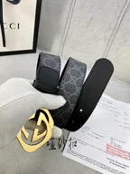 Black Gucci belt with GG monogram strap and gold-tone interlocking buckle close-up.