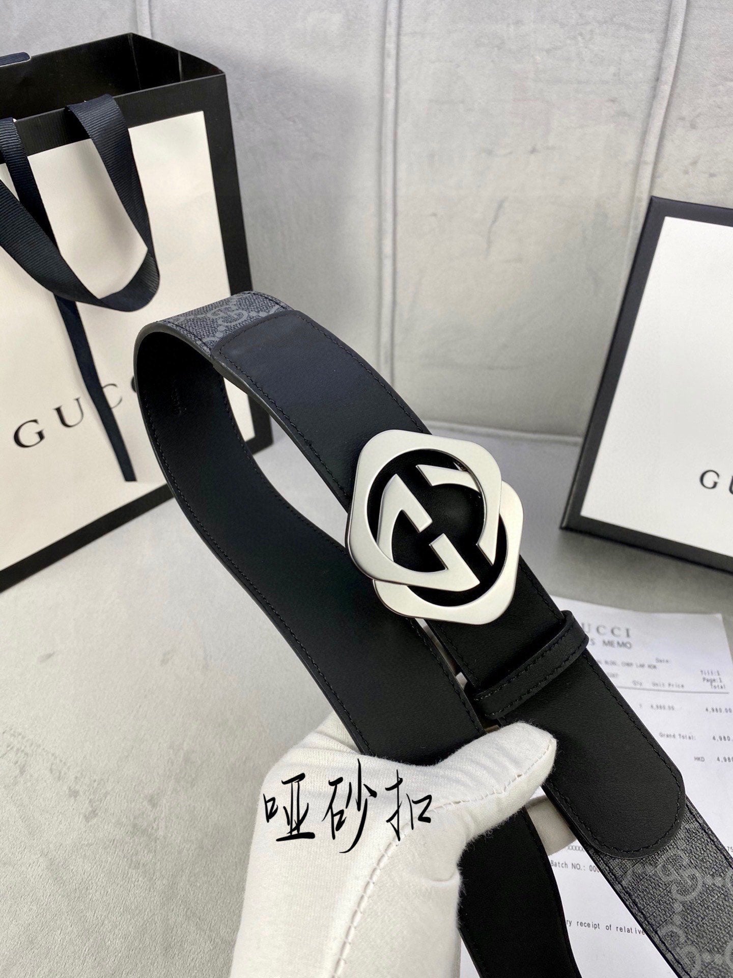 Black Gucci belt with GG monogram strap and silver-tone interlocking buckle.