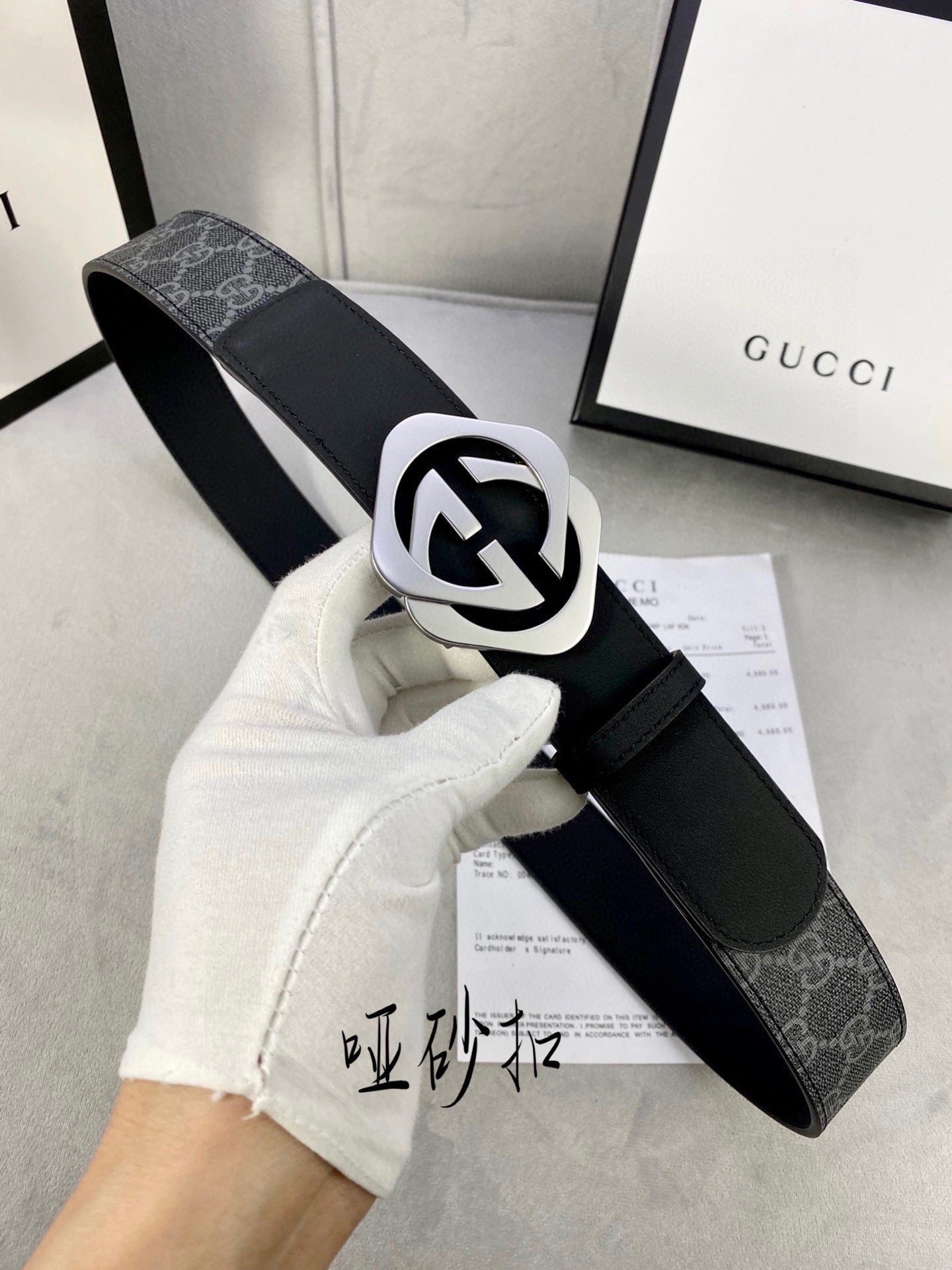 Black Gucci belt with GG monogram strap and silver-tone interlocking buckle.