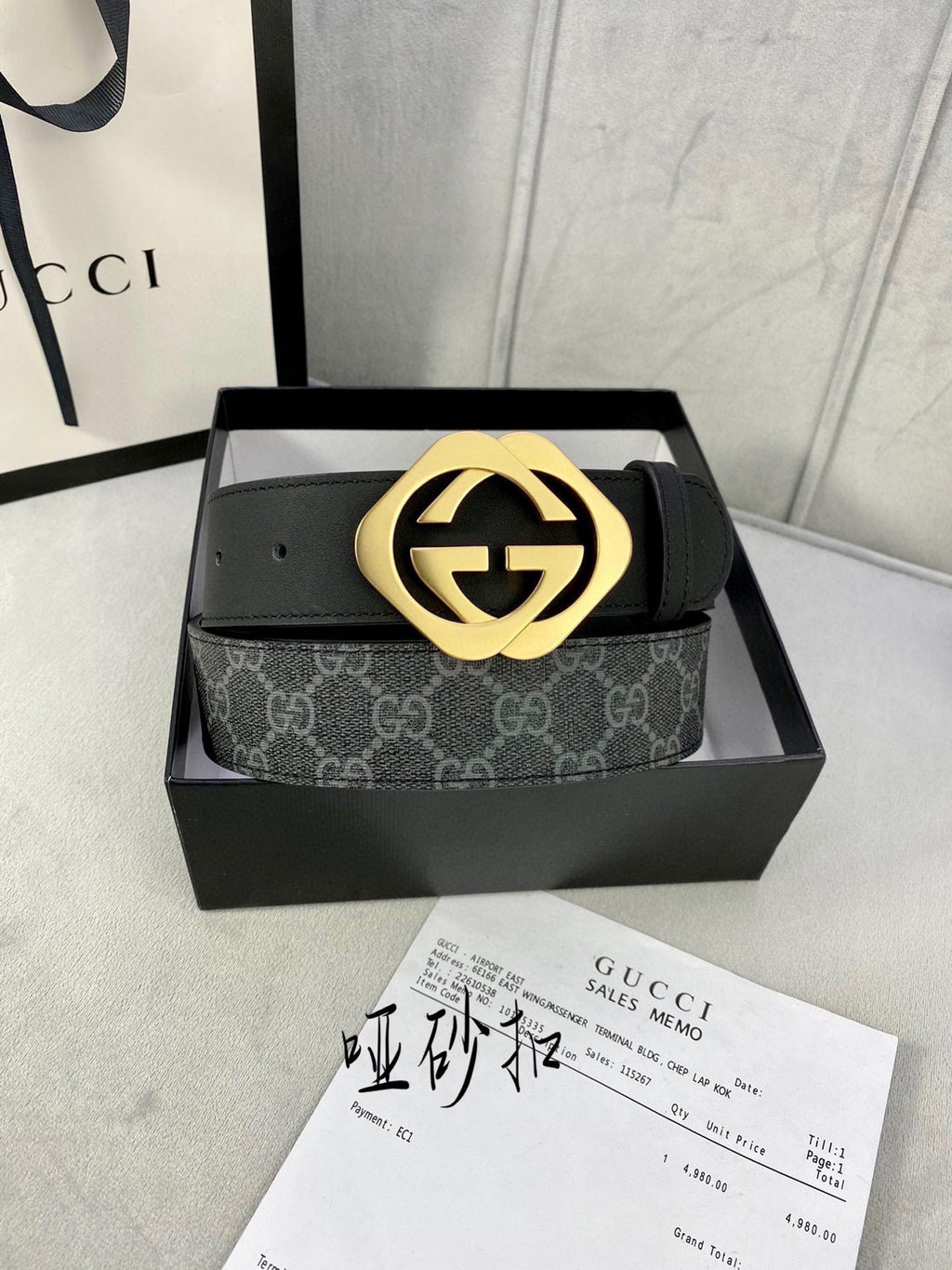 Black Gucci belt with GG monogram strap and gold-tone interlocking buckle.