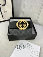 Black Gucci belt with GG monogram strap and gold-tone interlocking buckle.