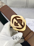 Gucci belt buckle close-up: gold-tone double-G on brown leather strap and GG canvas.