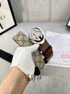 Gucci belt in hand: GG canvas and brown leather strap, silver-tone interlocking buckle.
