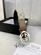 Gucci belt close-up with brown leather trim and GG canvas, silver-tone interlocking buckle.
