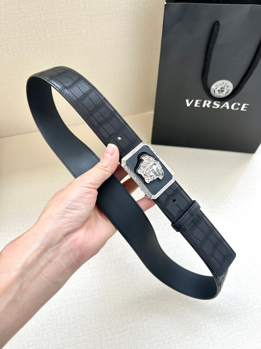 Navy leather belt with embossed texture and gold Medusa buckle, side view