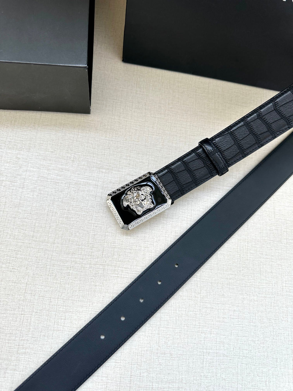 Navy leather belt with embossed texture and gold Medusa buckle with edge trim