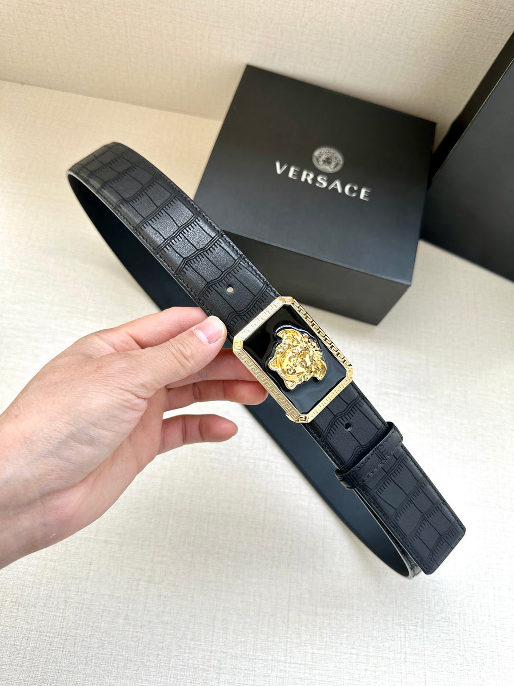 Navy leather belt with embossed texture and gold Medusa buckle