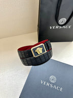 Belt: black textured belt with gold Medusa square buckle and red underside visible.