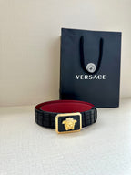 Belt: black textured strap with gold Medusa buckle and red underside visible.