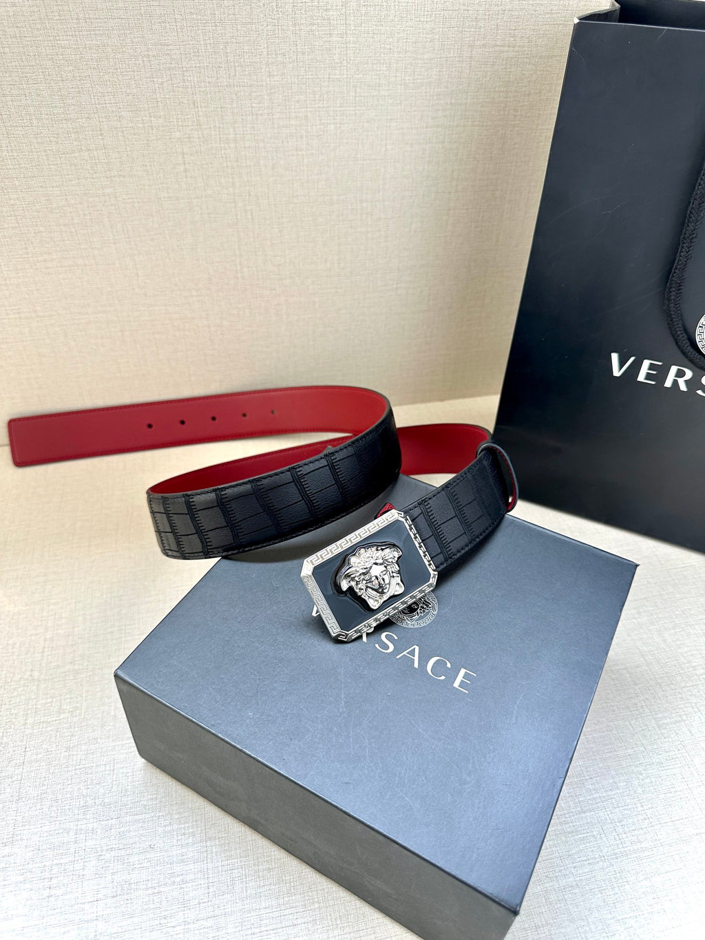 Belt: black with red underside, square Medusa buckle and adjustable strap.