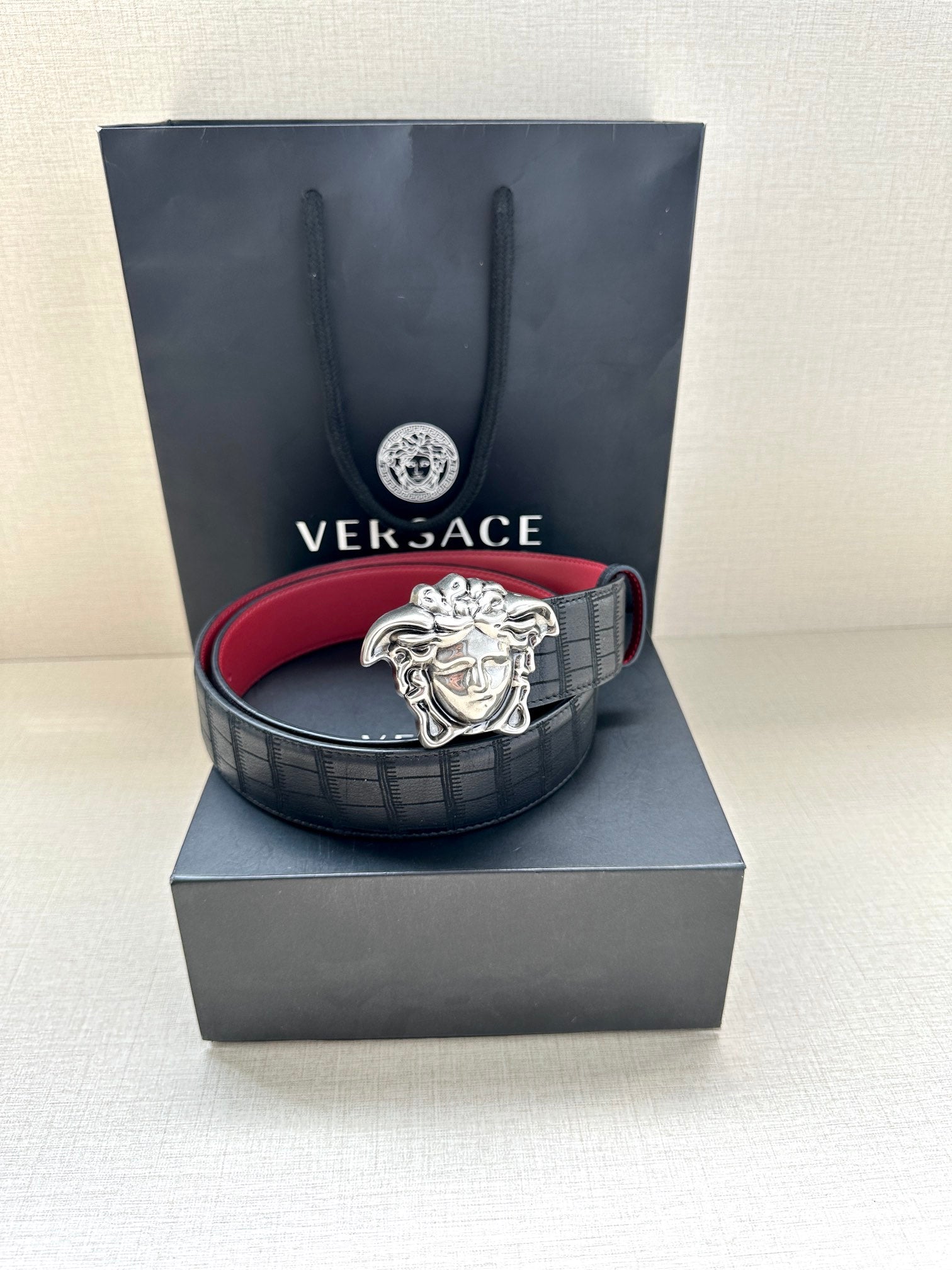 Black leather belt with red lining and silver Medusa medallion buckle