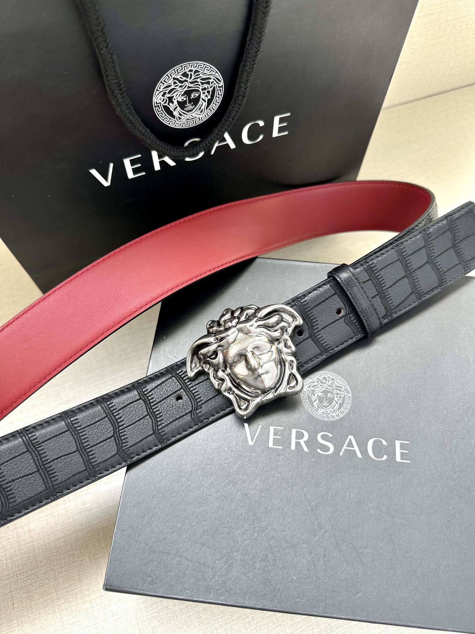 Black leather belt with red edge and silver Medusa medallion buckle