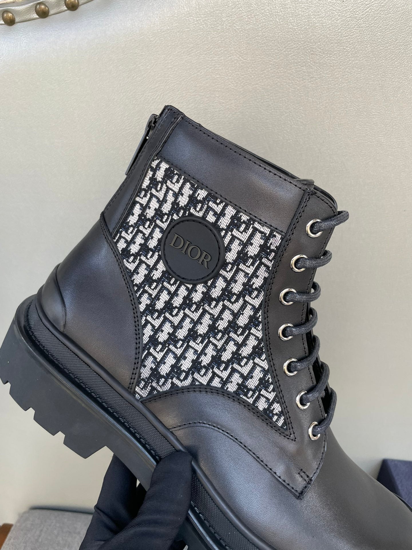 Dior lace-up ankle boot close-up, monogram knit insert and black leather upper
