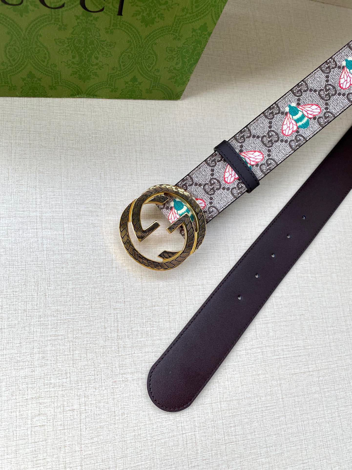 Gucci belt detail: GG canvas floral strap with gold buckle and dark leather end