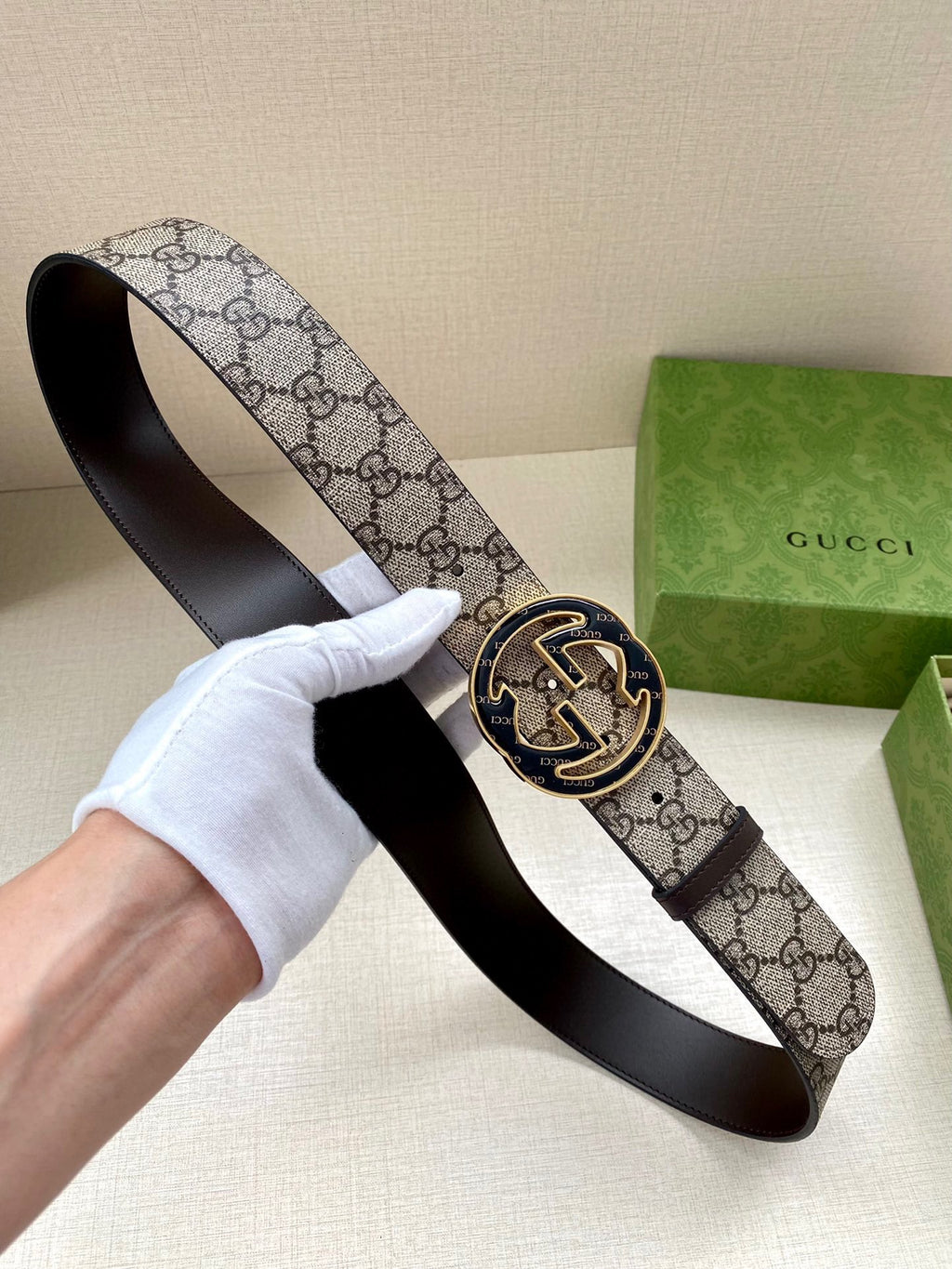 Gucci belt with GG monogram canvas strap and gold-tone horse buckle, shown end-on