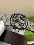 Gucci belt close-up of round dark buckle with GG pattern strap and keeper