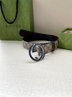 Gucci belt with GG monogram canvas and dark leather buckle, folded on display