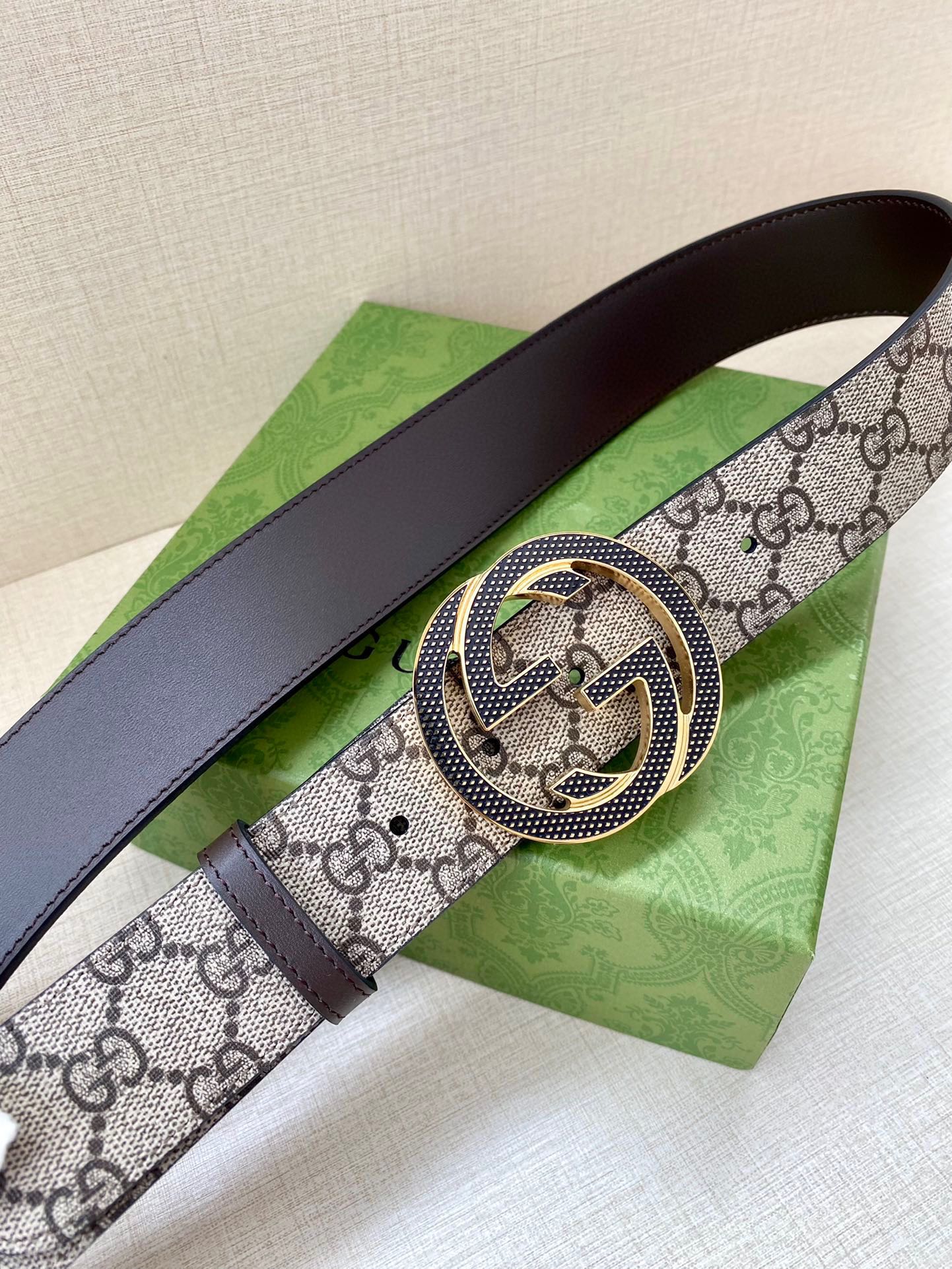 Gucci belt with GG monogram strap, round interlocking buckle, dark leather edges