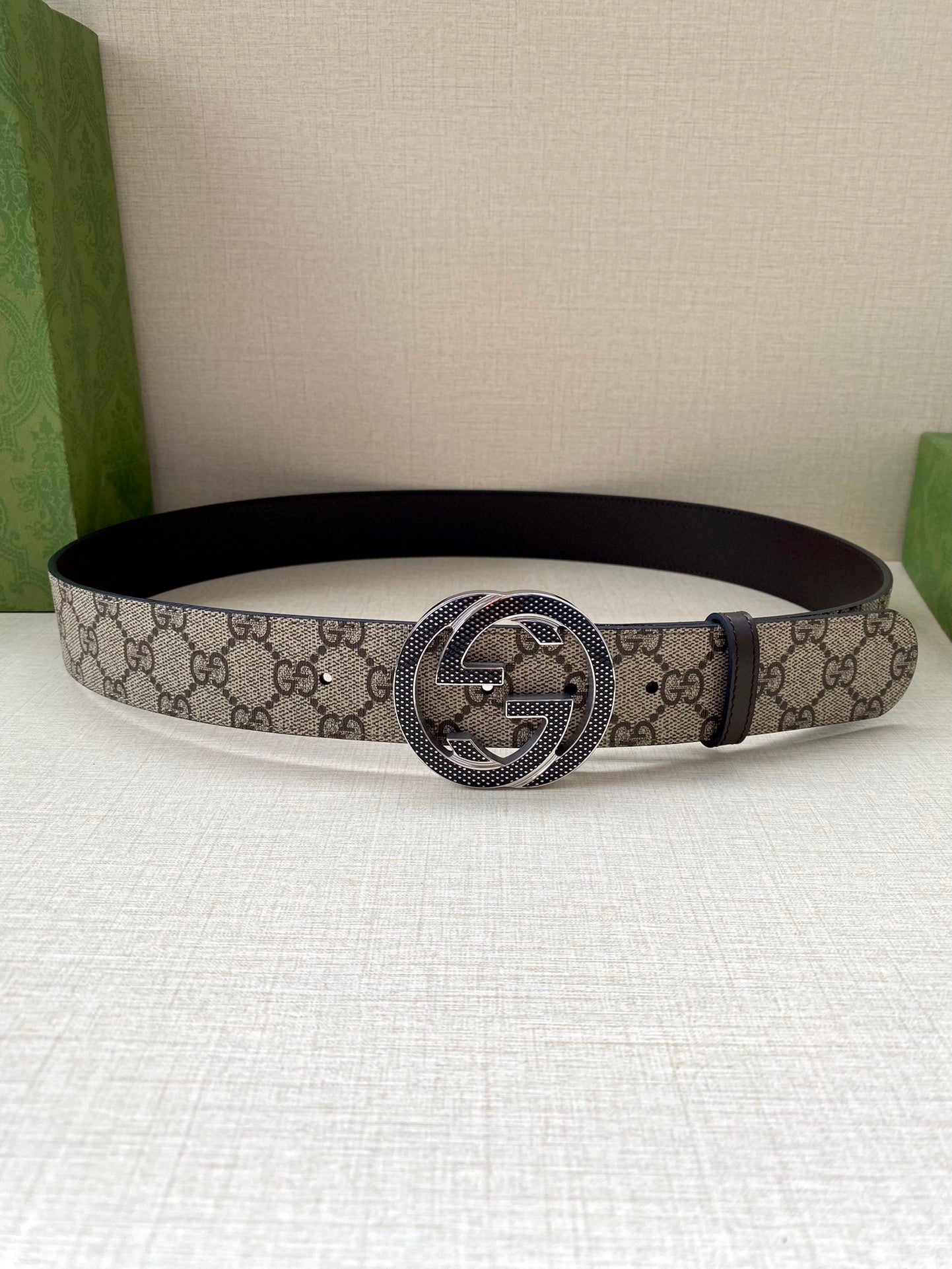 Gucci belt with GG monogram canvas and dark leather buckle on a flat loop
