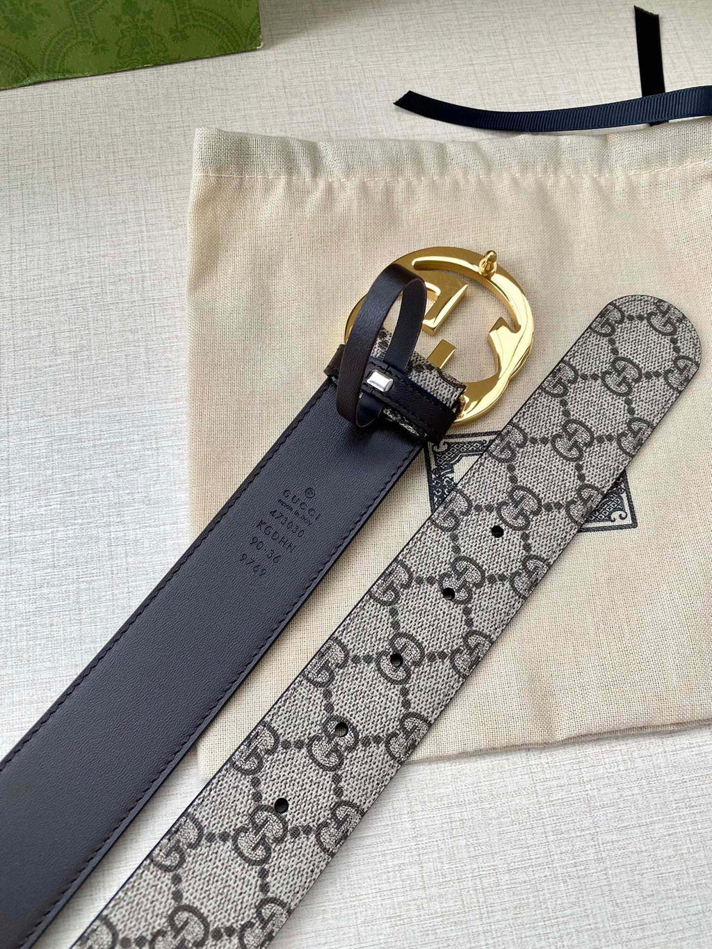 Gucci belt with GG monogram canvas strap and dark leather center, gold buckle detail