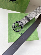 Gucci belt with GG monogram canvas strap and dark leather back, round silver buckle close-up