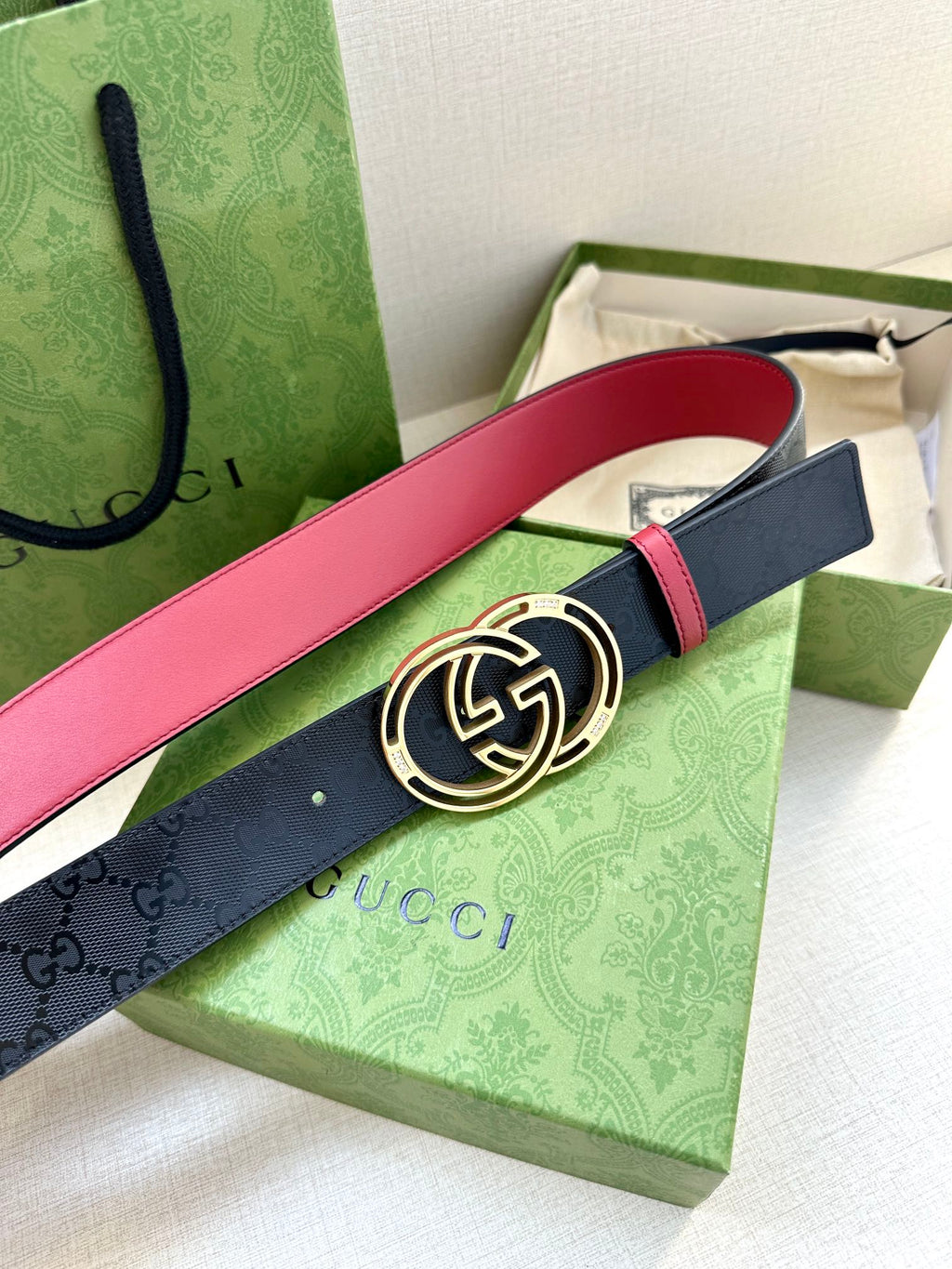 Gucci logo belt with round GG buckle, dark navy strap and red edge