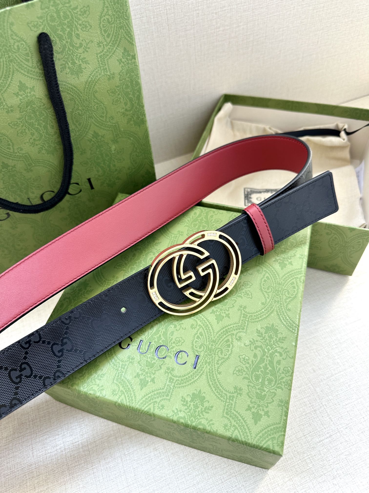 Gucci logo belt with round GG buckle, dark navy strap and red edge