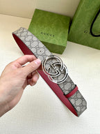 Gucci belt with gray GG monogram strap, red edge, and silver-tone GG buckle close-up
